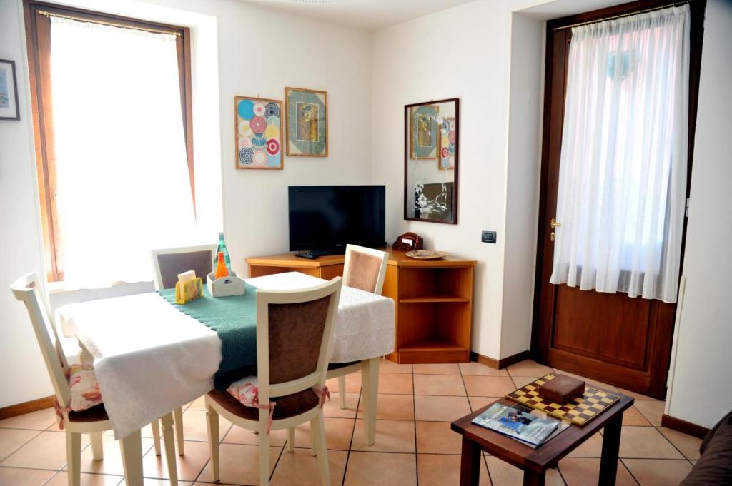 a living room with a table and a television at Casa Marina in San Pellegrino Terme
