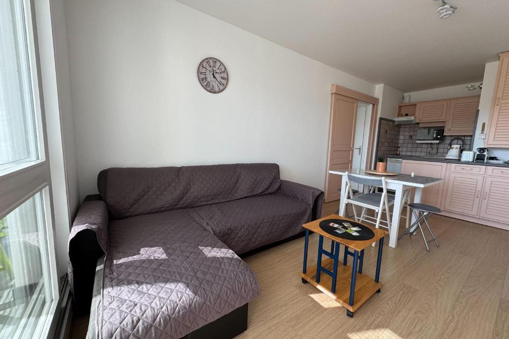 un salon avec un canapé et une table dans l'établissement Accommodation near the beach - Courseulles-sur-Mer, à Courseulles-sur-Mer