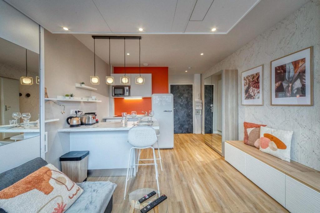une cuisine et un salon avec un comptoir et un bar dans l'établissement Le petit spacieux climatisation netflix, à Grenoble