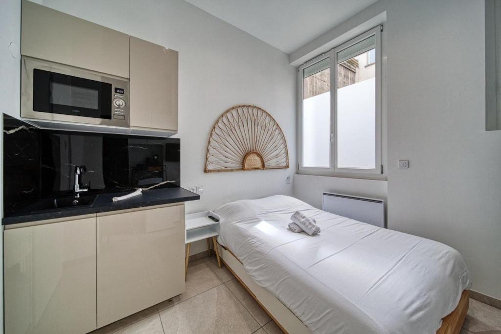 - une petite chambre avec un lit et un four micro-ondes dans l'établissement La petite estacade 4, à Grenoble