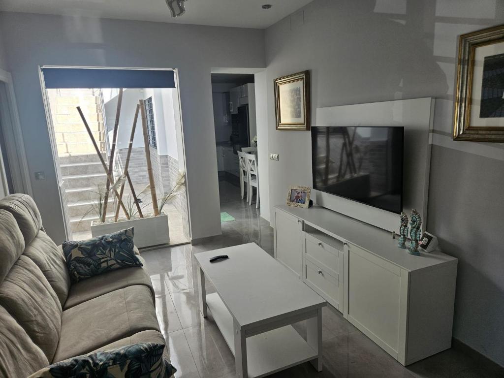 a living room with a couch and a tv at Casa Marcé in Córdoba