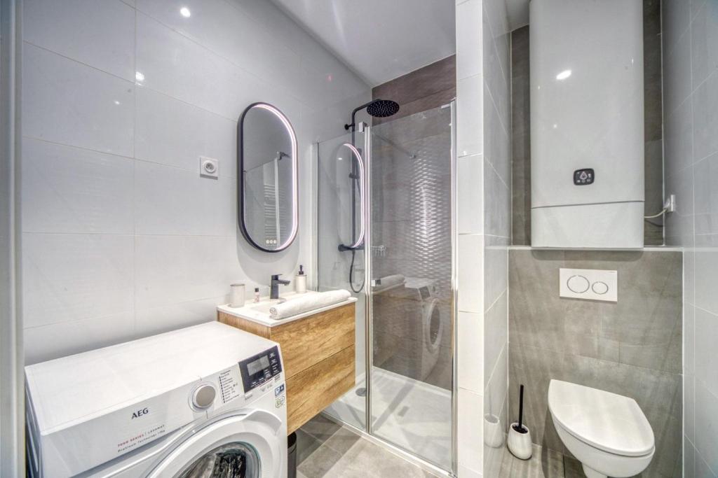 une salle de bain avec machine à laver et toilettes dans l'établissement Le félix 1, à Grenoble