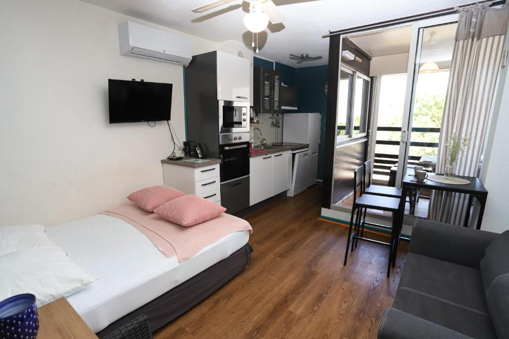 une chambre avec un lit et une cuisine avec une table dans l'établissement Studio au centre de St Cyp plage, à Saint-Cyprien
