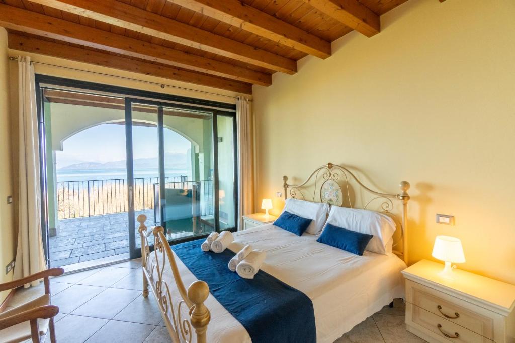 ein Schlafzimmer mit einem Bett und einem großen Fenster in der Unterkunft Home MiraGarda in Peschiera del Garda