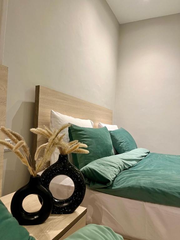 Un dormitorio con una cama con un jarrón negro sobre una mesa. en AURORA PYRAMIDS HOTELl, en El Cairo