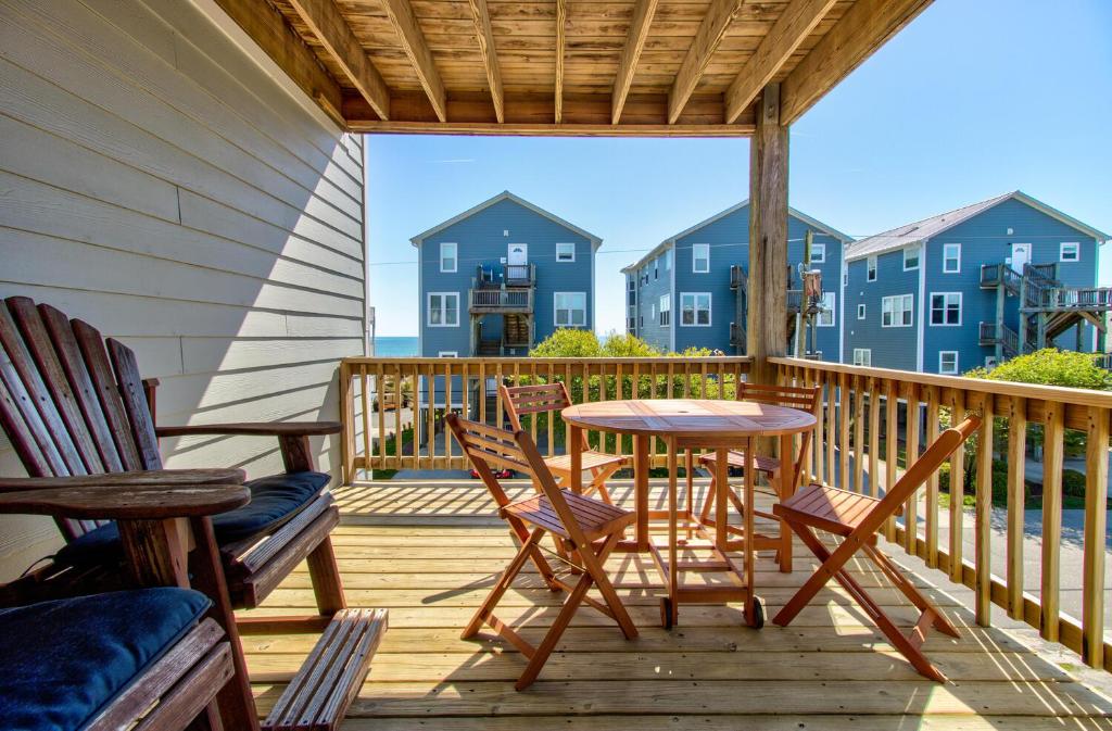 un patio con sedie e un tavolo su un ponte di Sea Drift 200: Breezy by Carolina Beach Realty a Carolina Beach