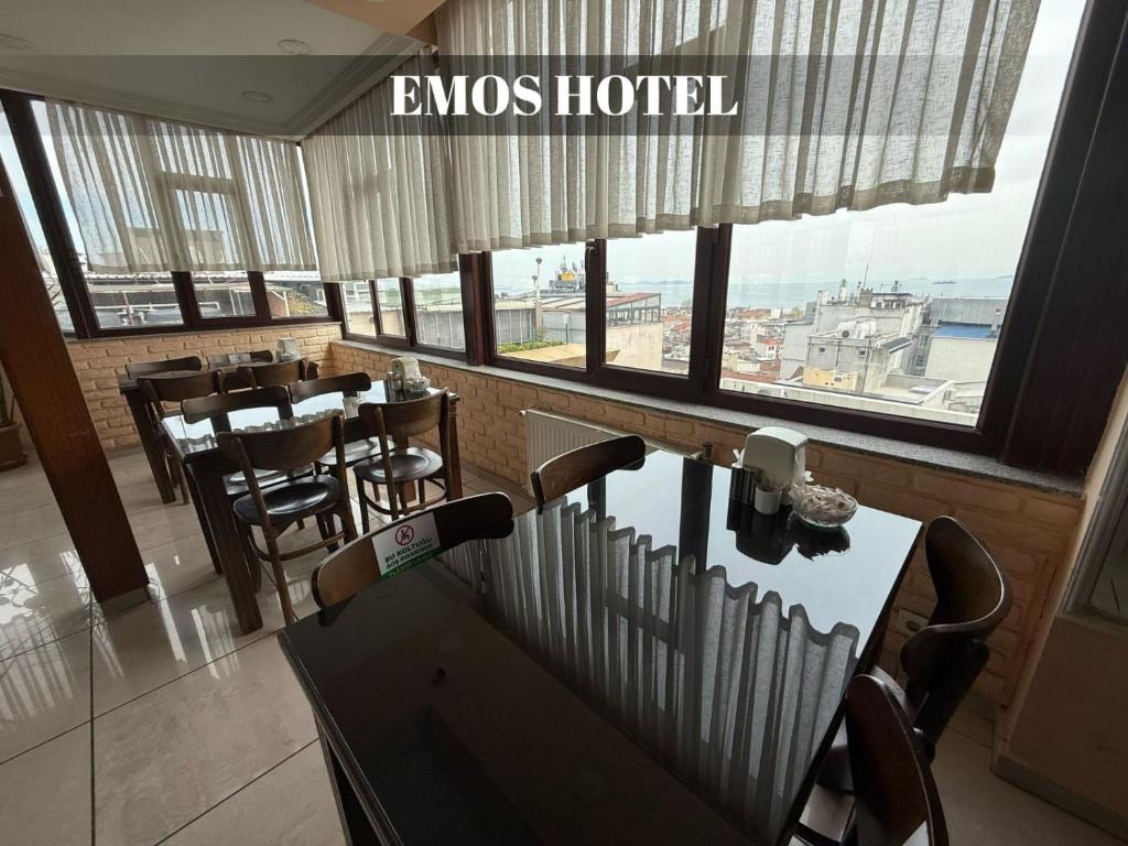 a restaurant with tables and chairs and a large window at EMOS HOTEL in Istanbul