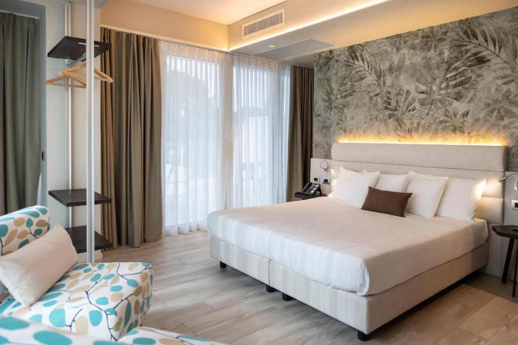 a hotel room with a bed and a chair at Vision Hotel in Peschiera del Garda