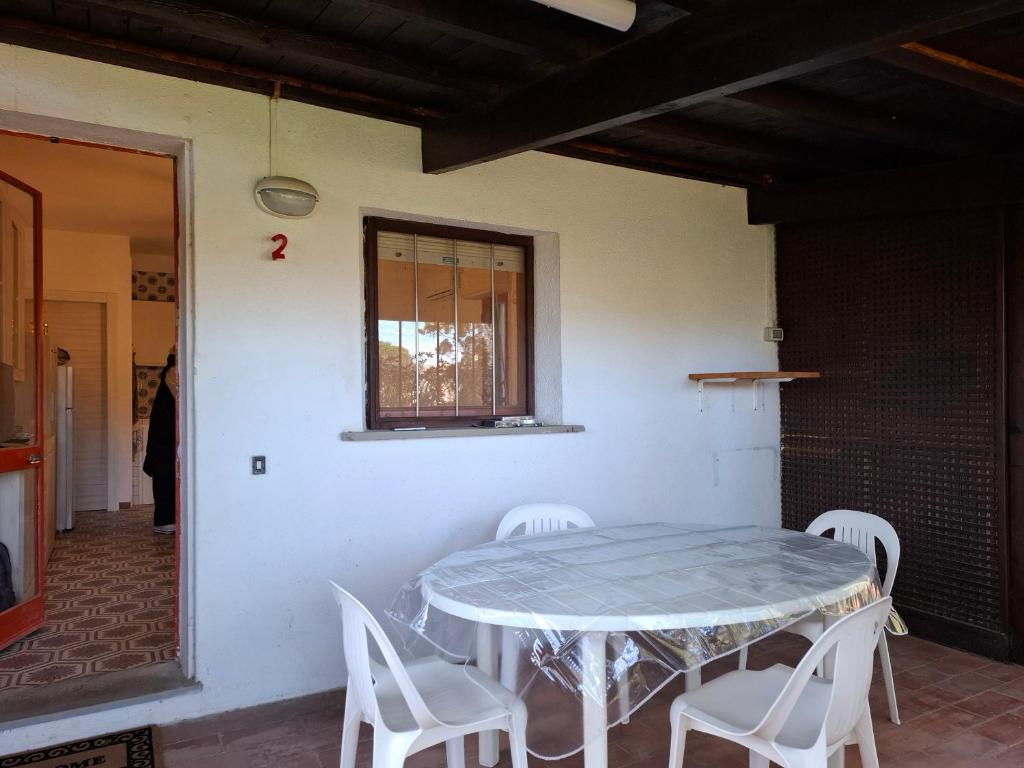 a table and chairs in a room with a window at Casa Leone in Stintino