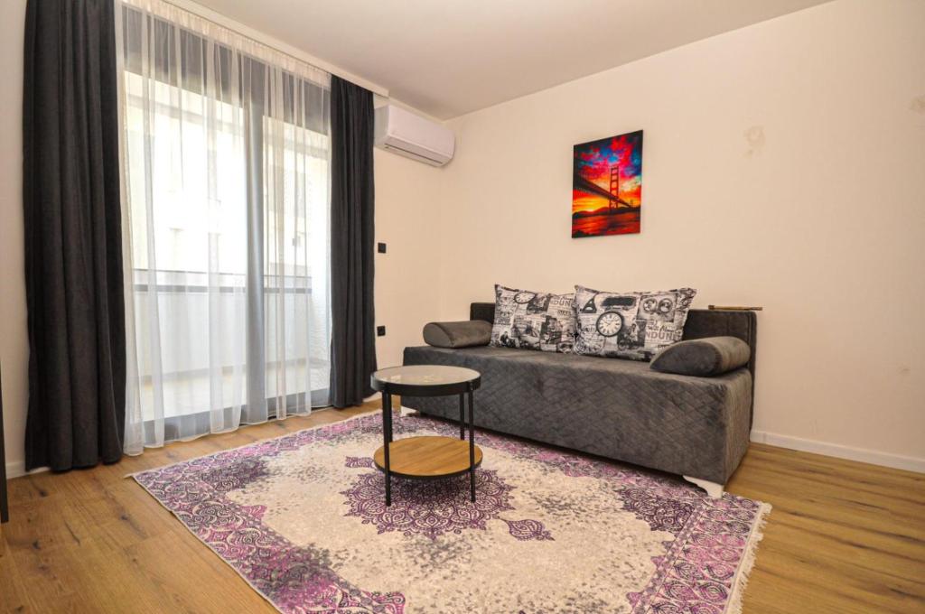 una sala de estar con un sofá y una mesa en Studio Dobra Voda 13, en Dobra Voda