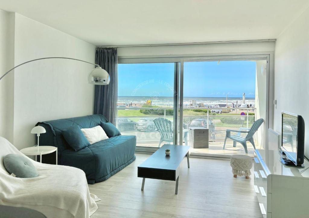 un salon avec un canapé et une vue sur l'océan dans l'établissement Côté Mer, à Le Touquet-Paris-Plage