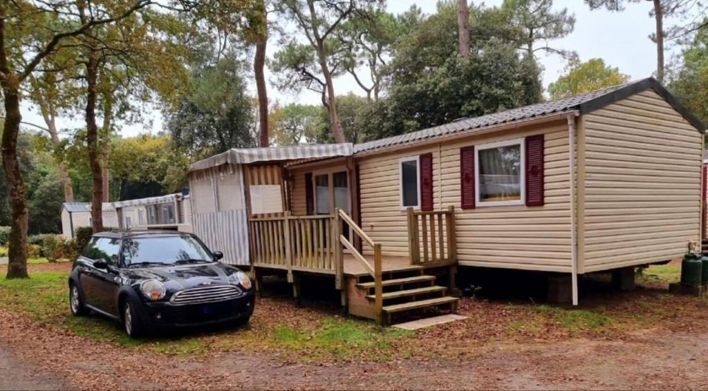 une petite maison avec une voiture garée devant dans l'établissement LOCATION MOBIL HOME 40m carré de 2 à 8 personnes en bords de mer, à Saint-Brévin-lʼOcéan