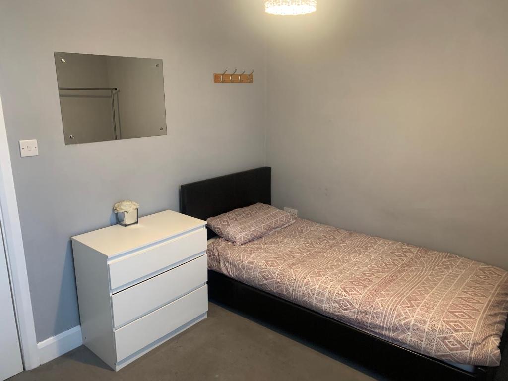 a small bedroom with a bed and a dresser at North London Room in Enfield Lock