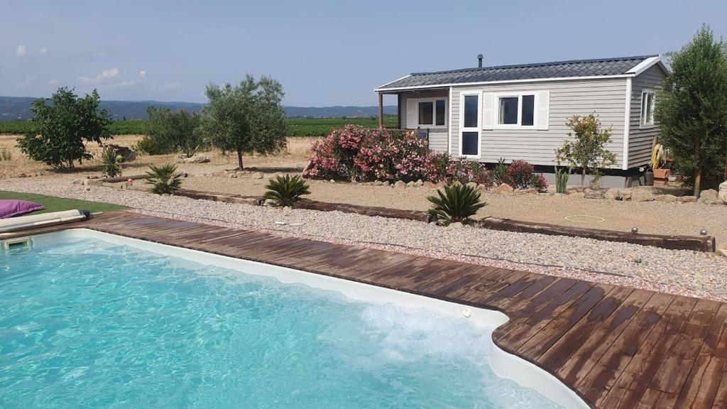 une piscine en face d'une petite maison dans l'établissement Séjour au cœur du Minervois, à Azille
