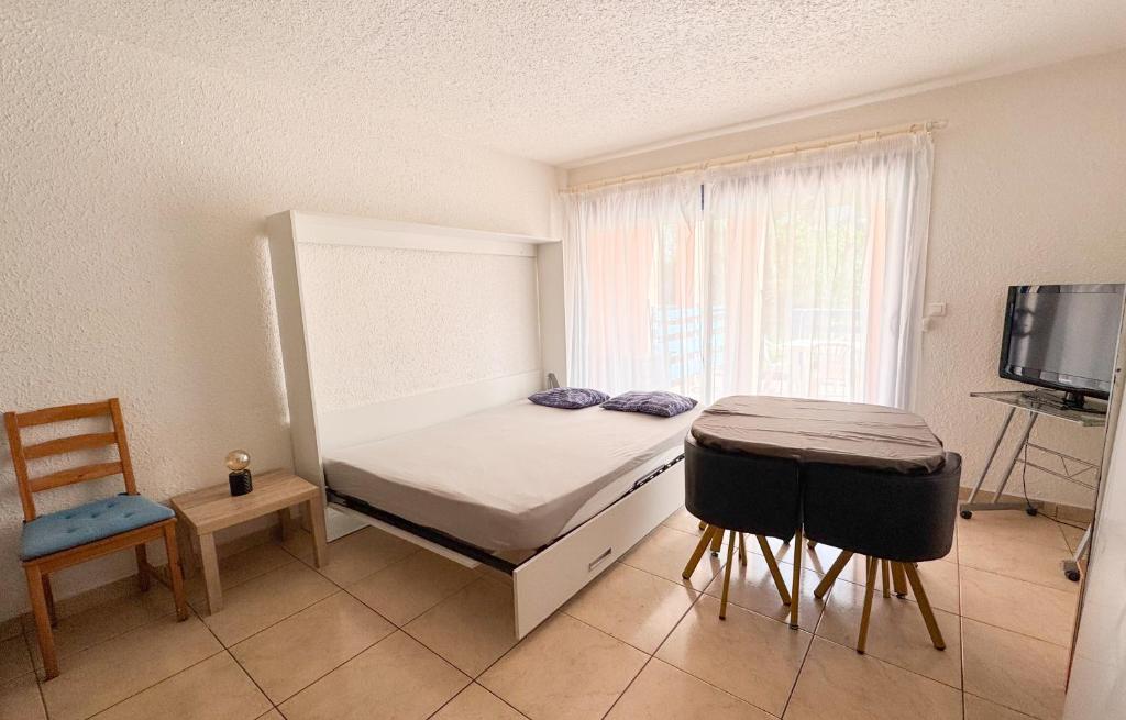 une chambre avec un lit, une table et une fenêtre dans l'établissement Jolie Studio dans Village de vacances - Miami 26, à Canet