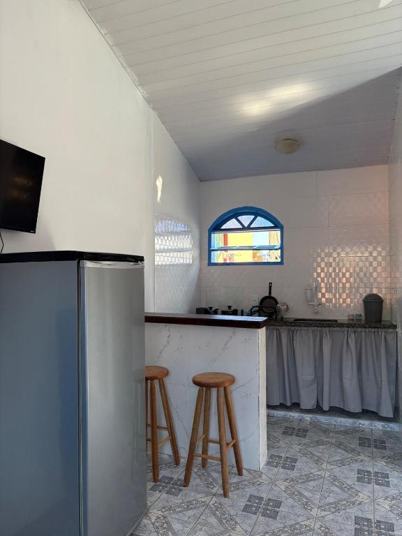 een keuken met een aanrecht en krukken in een kamer bij Kitnet Brava 2 in Búzios