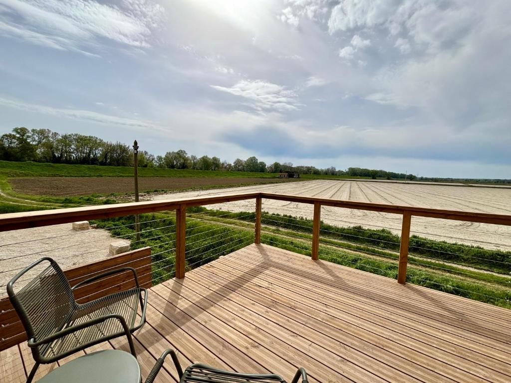 une terrasse en bois avec un banc et un champ dans l'établissement Peaceful Provence - modern countryside tower, à Fourques