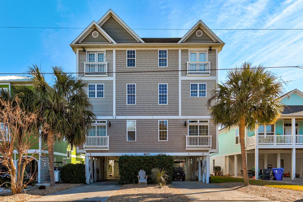 a large house with palm trees in front of it at Jacks Beach House by Carolina Beach Realty in Carolina Beach