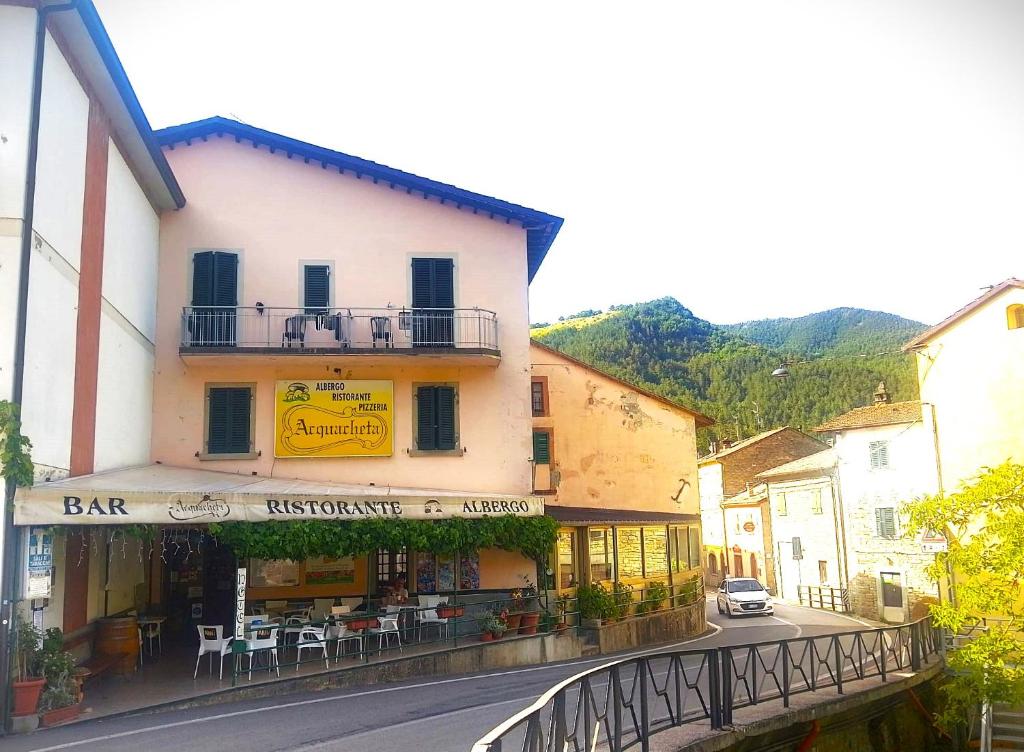 ulica w mieście z budynkiem ze stołami i krzesłami w obiekcie Acquacheta Valtancoli Hotel B&B w mieście San Benedetto in Alpe