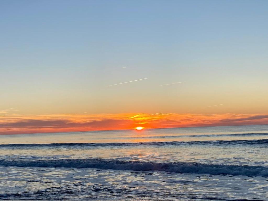 - un coucher de soleil sur la plage avec l'océan dans l'établissement Mobile home in 5-star camping, à Montalivet-les-Bains