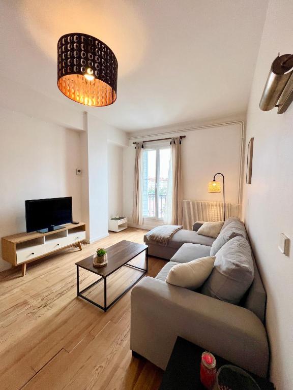 un salon avec un canapé et une télévision dans l'établissement L'Ecume, à Royan