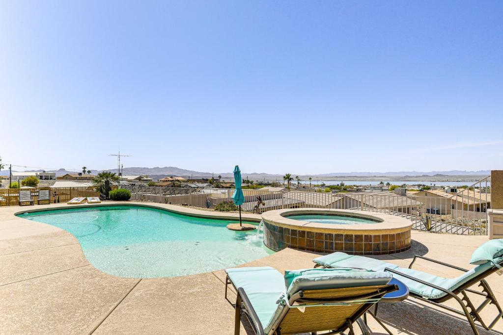 ein Swimmingpool mit zwei Stühlen und einem Sonnenschirm in der Unterkunft Lake View and Games Spacious Oasis in Lake Havasu! in Lake Havasu City