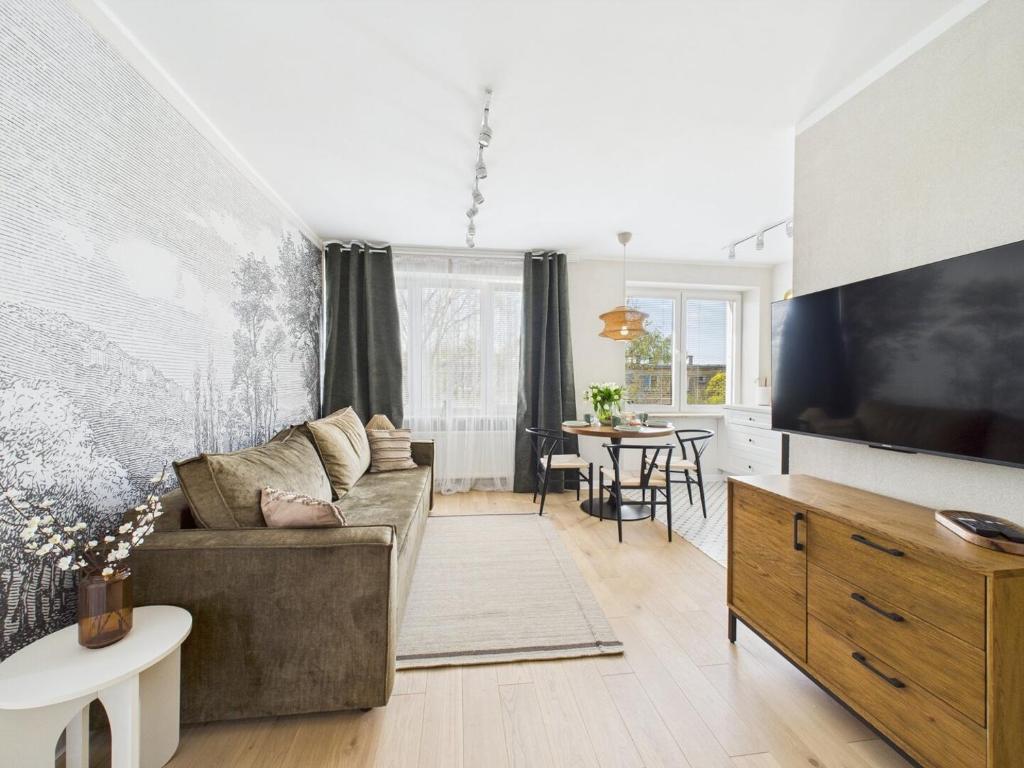 Una sala de estar con un sofá y un televisor. en ApartamentySnu, Bema, en Radom