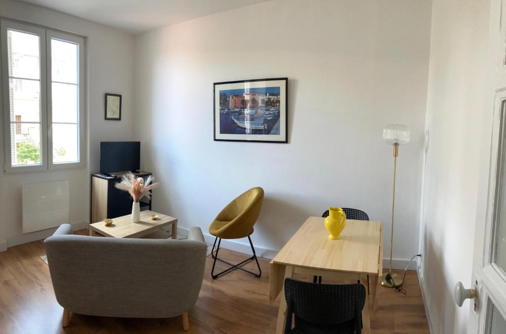un salon avec une table et une chaise dans l'établissement T2 Ajaccio - A deux pas de la plage, à Ajaccio