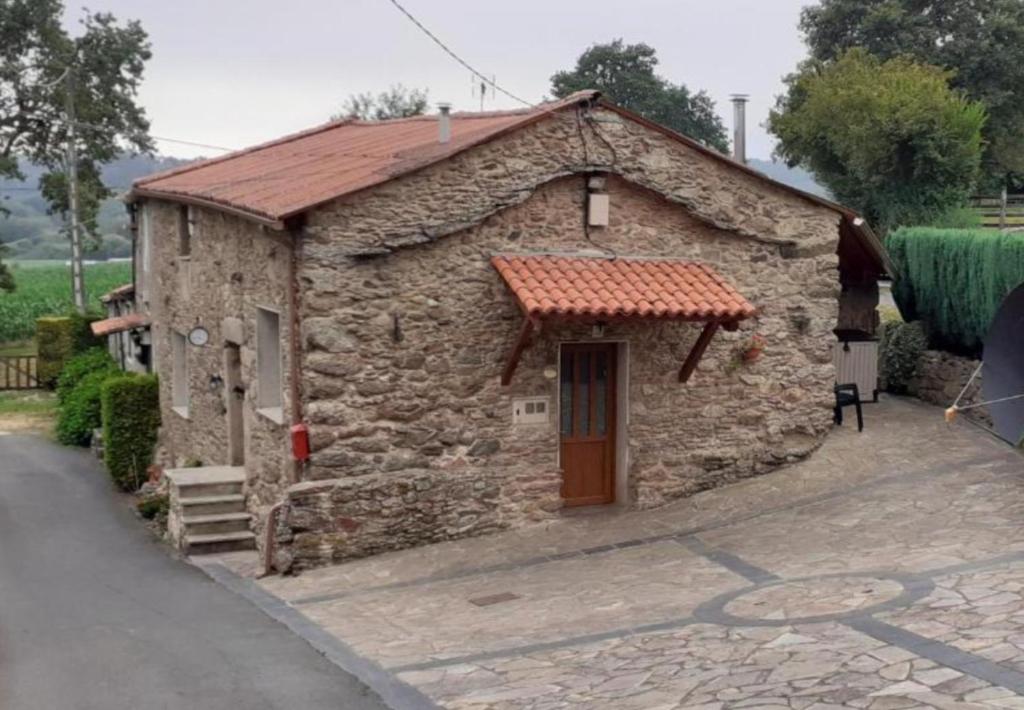 a small stone building with a red roof at Stone Cottage La COMPOSTELANA in Curtis