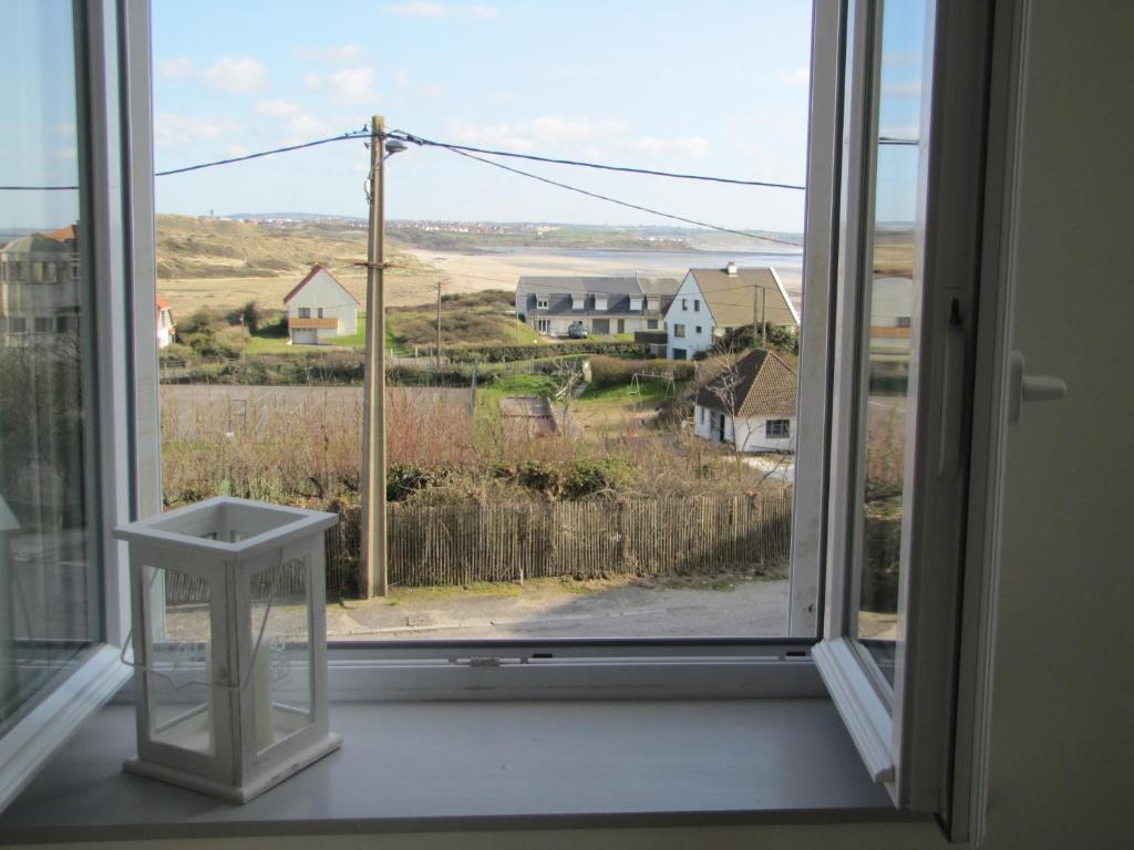 een open raam met uitzicht op een huis bij Chez Jules in Ambleteuse