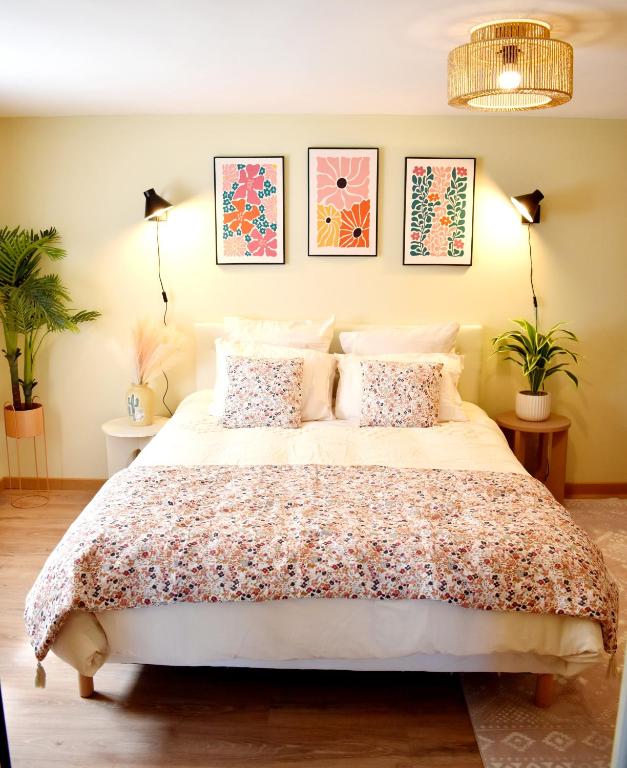 une chambre avec un grand lit avec deux plantes dans l'établissement La licorne poitevine, à Poitiers