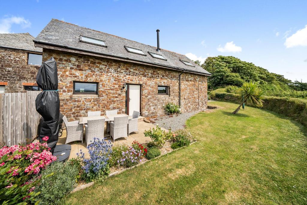 a brick house with chairs and a garden at Coast View in Bideford