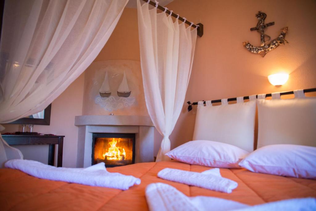 - une chambre avec un lit avec deux oreillers et une cheminée dans l'établissement Kallisto Guesthouse, à Tsagkarada