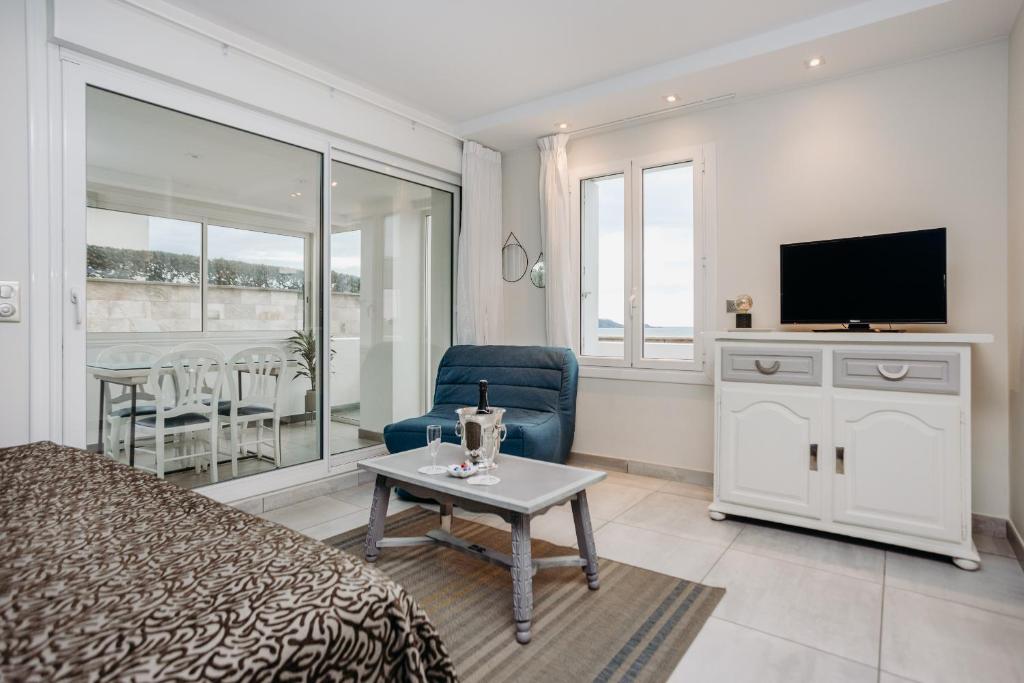 a bedroom with a bed and a tv and a table at Résidence ITXASOA - Appartements, plage d'Hendaye in Hendaye