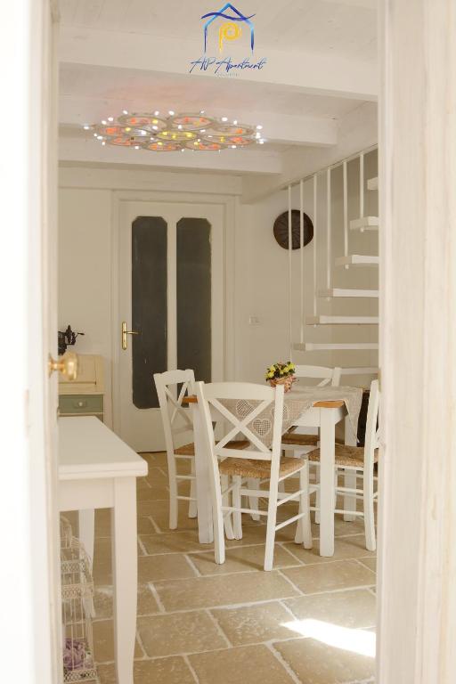 a white dining room with a table and chairs at Mescia Alba x AP Apartment in Gallipoli