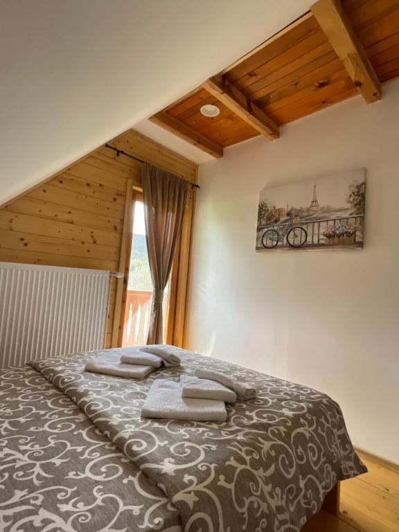 a bedroom with a bed with towels on it at Mokrogorski konaci in Mokra Gora
