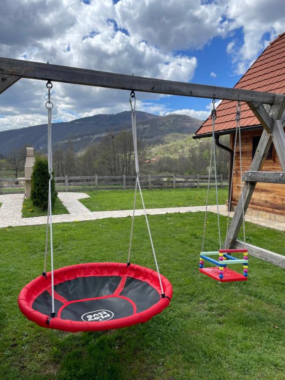 a swing set in a yard with mountains in the background at Mokrogorski konaci in Mokra Gora