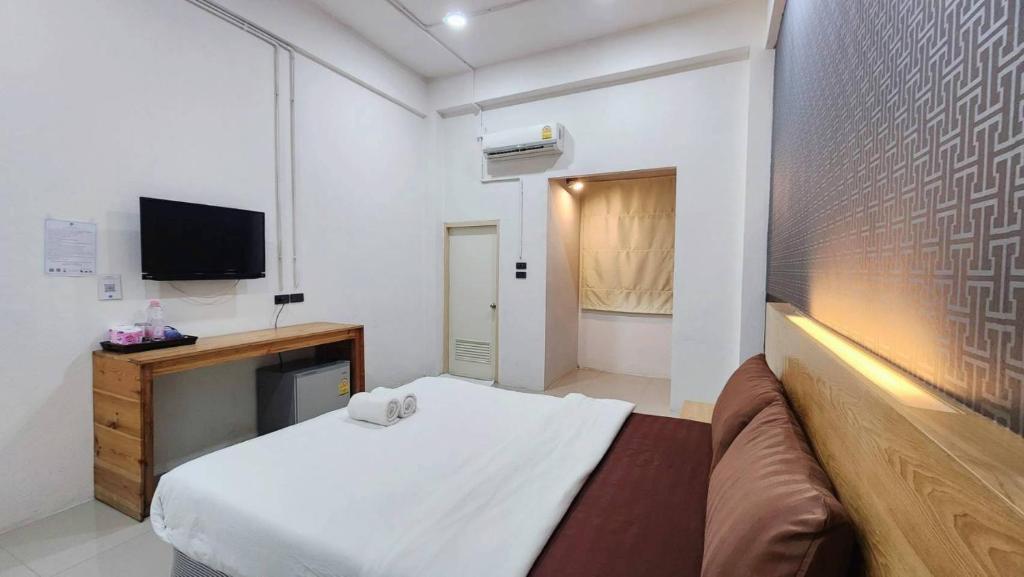 A double room photographed from the bed, with a TV console and curtained opening.