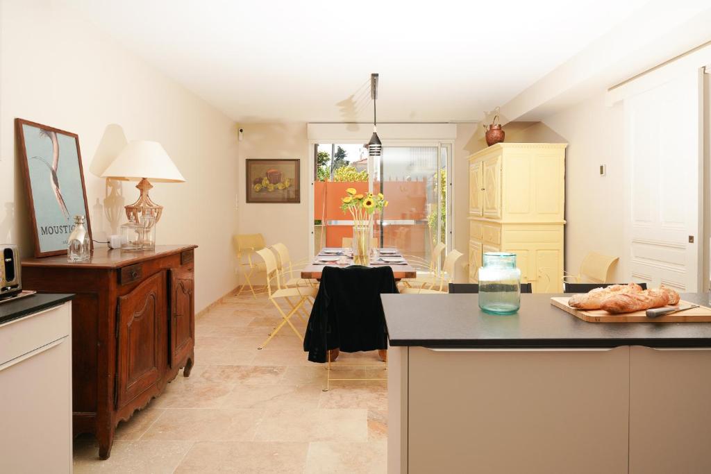 - une cuisine avec un comptoir et une table dans une pièce dans l'établissement Maison Pamplemousse, à Arles