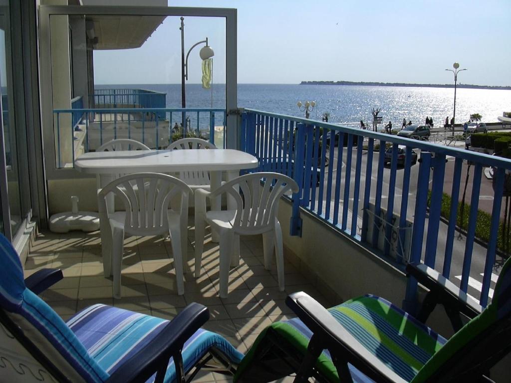 un balcon avec des chaises et une table et l'océan dans l'établissement LA BAULE BORD DE MER APPT 2 pièces vue latérale mer 4 PERS, à La Baule
