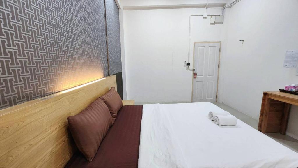 A compact double bedroom with a timber headboard and small work table.