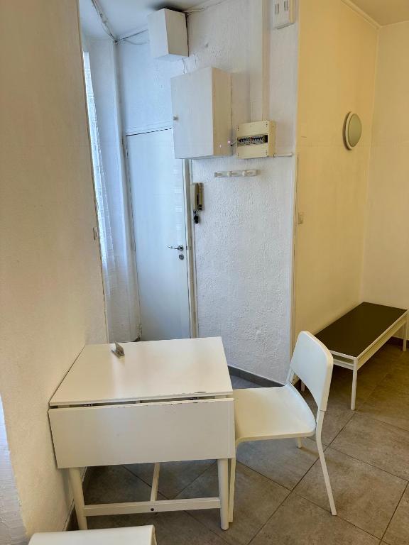 Cette chambre comprend une table, une chaise et un réfrigérateur. dans l'établissement Un studio sympa en centre-ville rue du camas, à Marseille