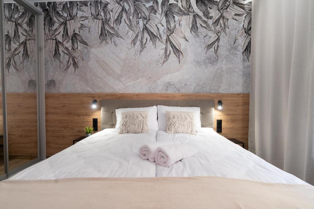 sypialnia z białym łóżkiem i 2 ręcznikami w obiekcie Flow Apartments - przy Mariackiej w mieście Katowice