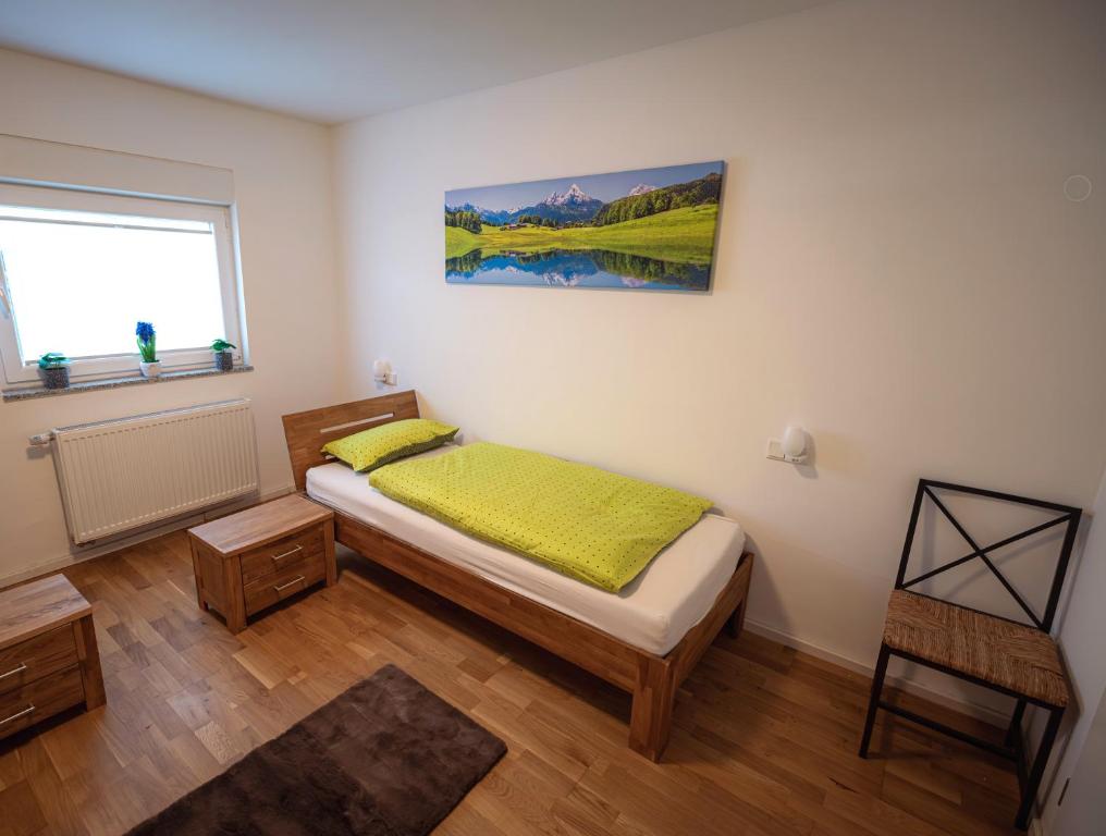 a small bedroom with a bed and a window at Wohlfühloase - Moderne Ferienwohnung mit großem eingezäuntem Garten in Alleinlage an Feld & Wald, Natur pur trifft auf Komfort, Wellness und gute Erholung in Alpen