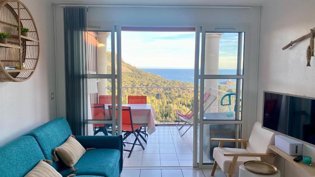 un salon avec un canapé et une vue sur l'océan dans l'établissement Le rêve d'azur, à Saint-Raphaël