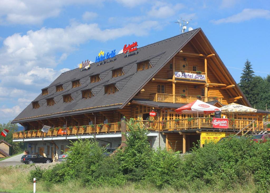 duży drewniany budynek z czarnym dachem w obiekcie Hotel Grůň w Mostach koło Jabłonkowa