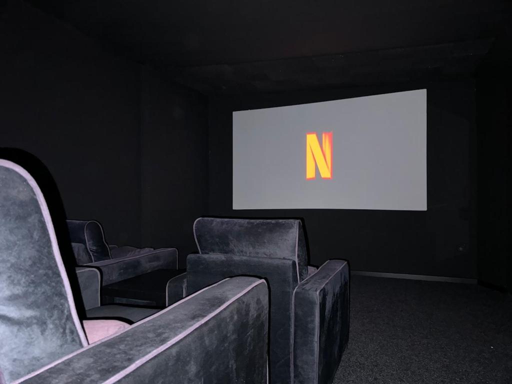 a room with two chairs and a screen with the letter n at Entspannung pur! Privater Kinosaal & Whirlpool in Essen
