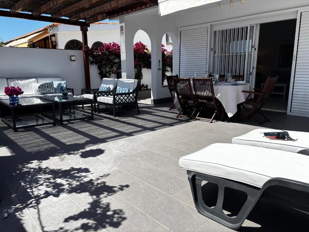 patio z krzesłami, stołami i stołem w obiekcie Espacioso Bungalow 2 dormitorios en Maspalomas w mieście Maspalomas