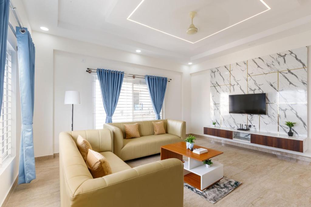 a living room with a couch and a tv at OBS Serviced Apartments HSR Layout Bangalore in Bengaluru