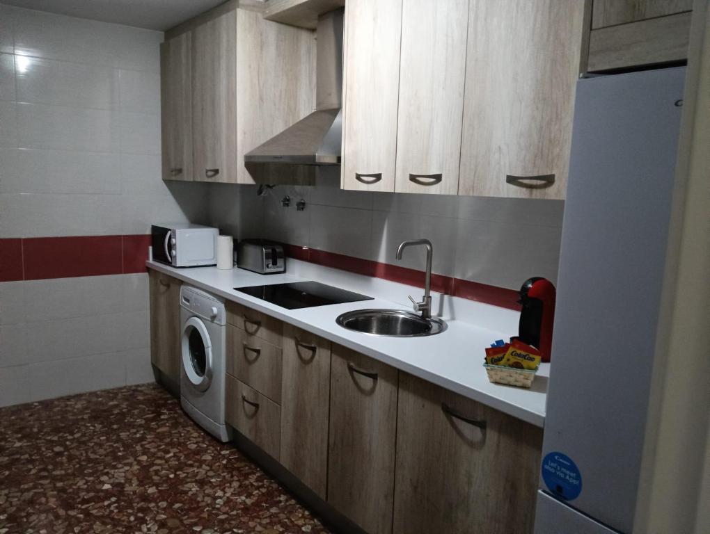 a kitchen with a sink and a washing machine at Casa Paco in Linares
